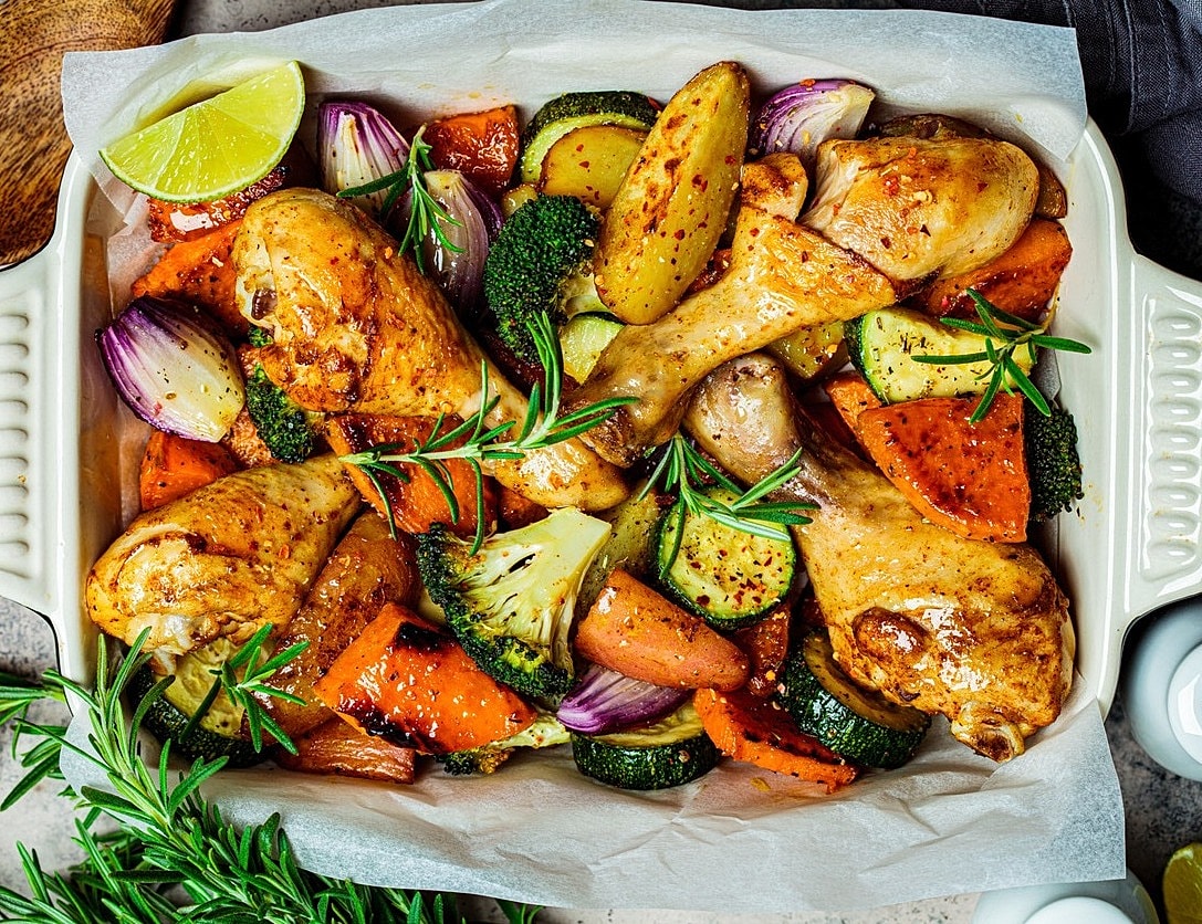 Roasted chicken drumsticks with mixed vegetables.