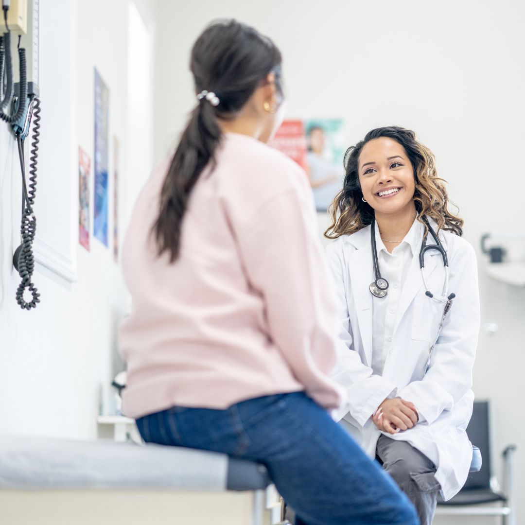 Hands holding white daisies in sunlight.