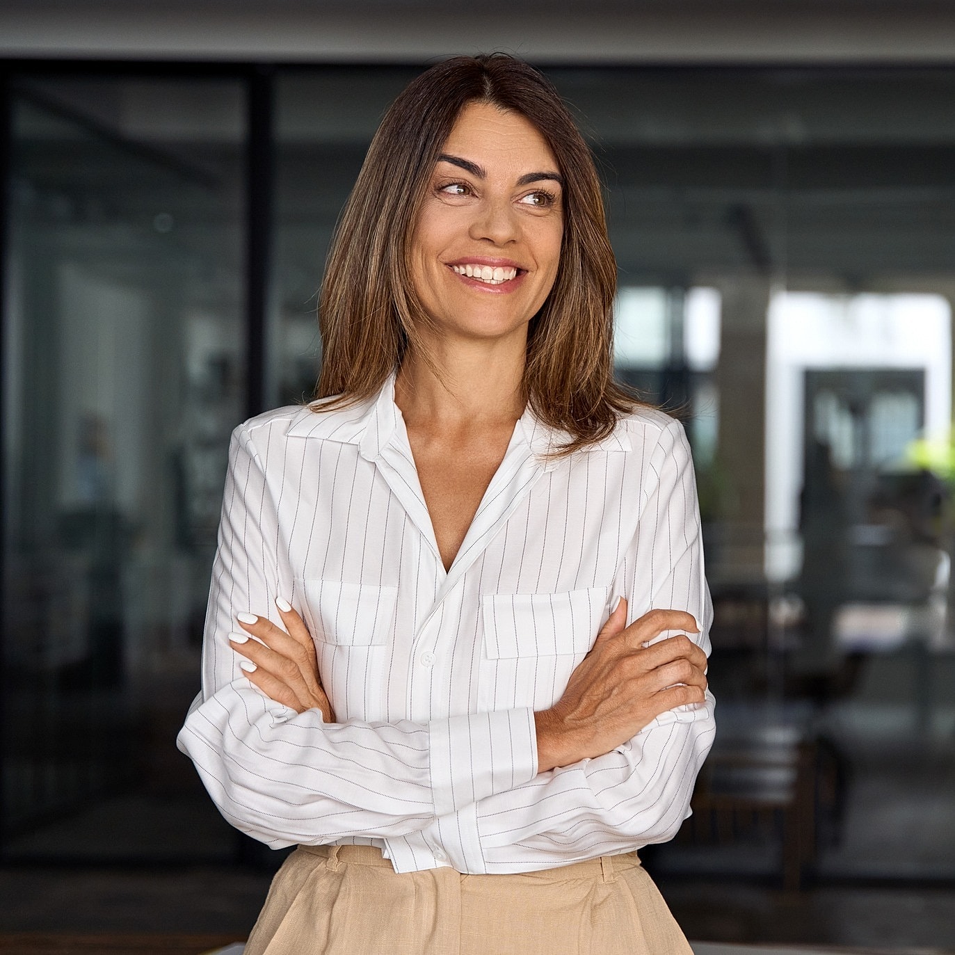 Smiling woman in a striped shirt, arms crossed.