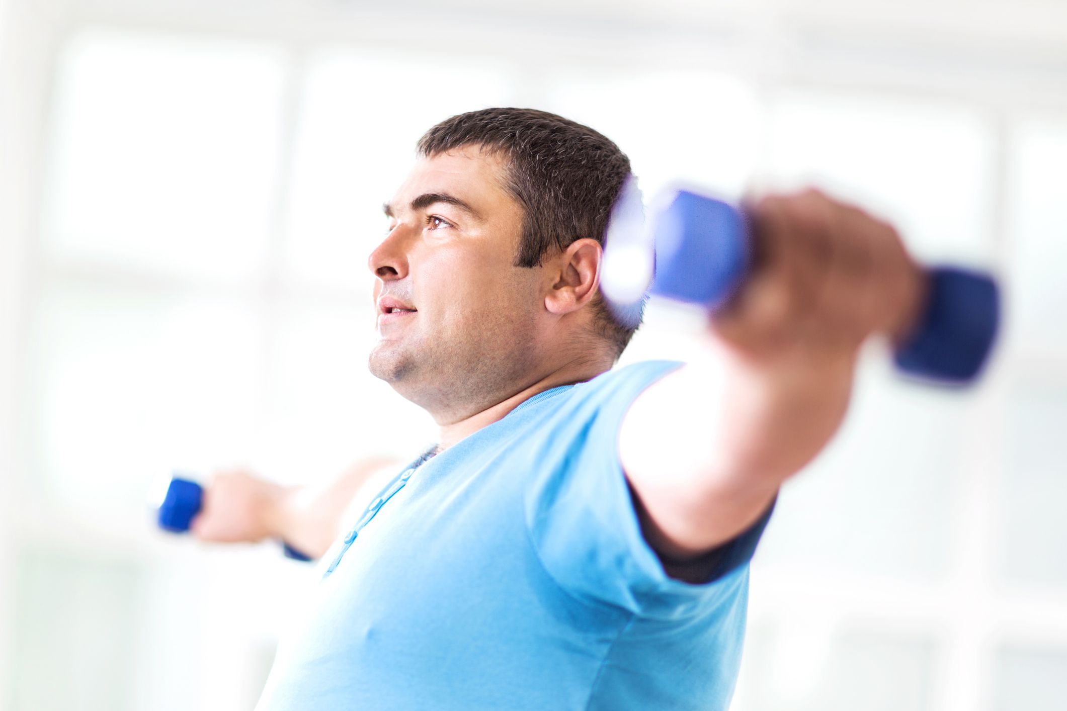 Man exercising with dumbbells in gym setting