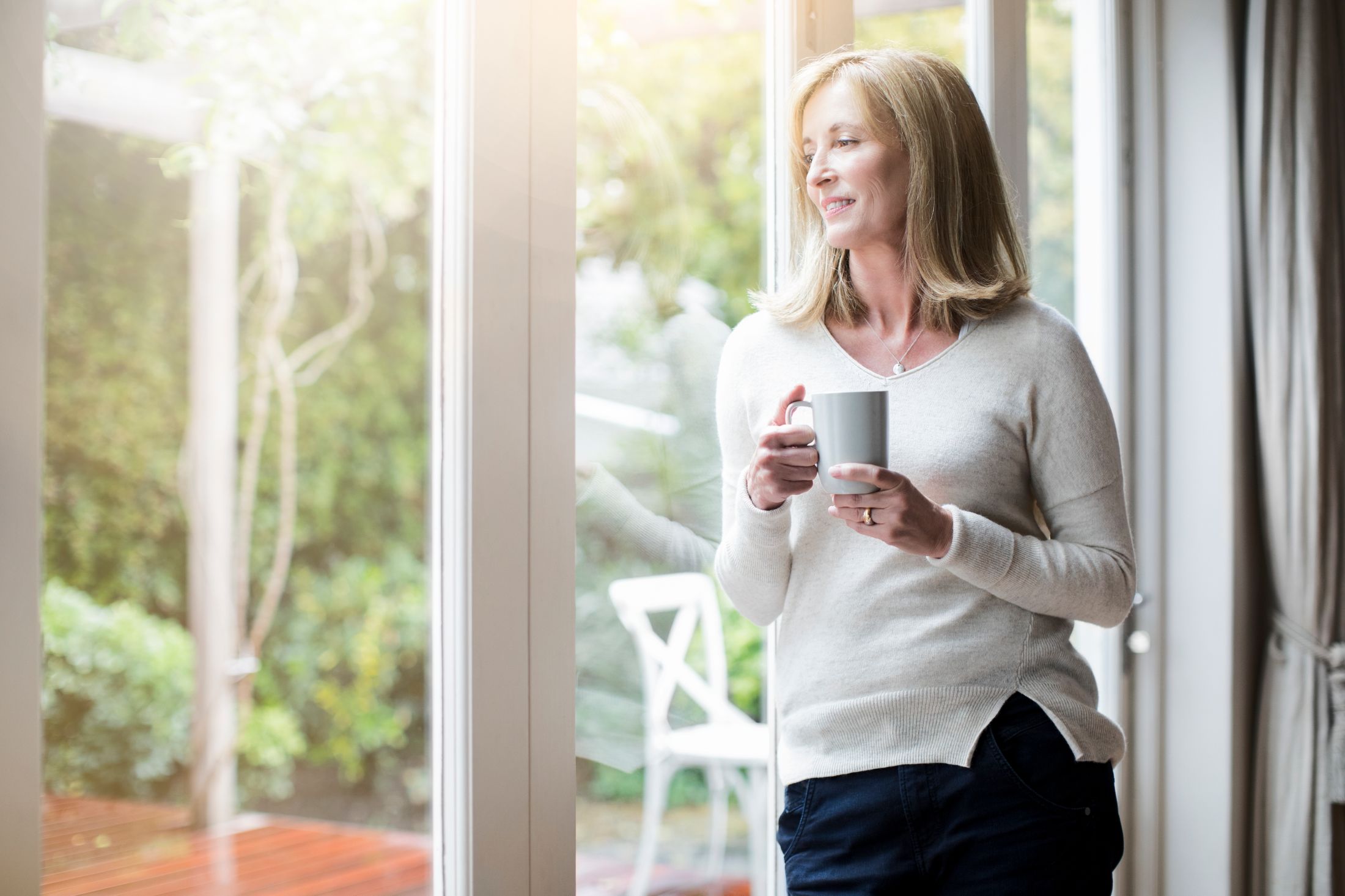 Woman enjoying a cup of coffee by the window.
